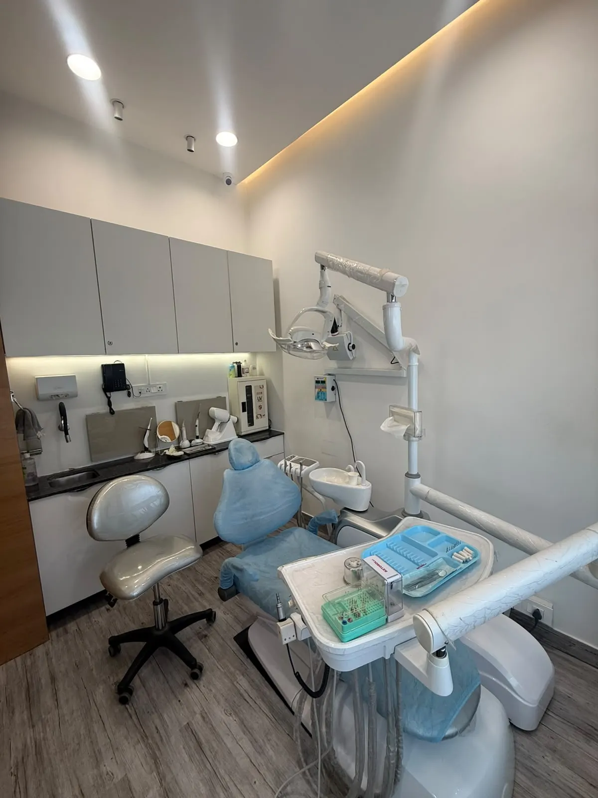 A treatment room with a dental chair under soft cove lighting