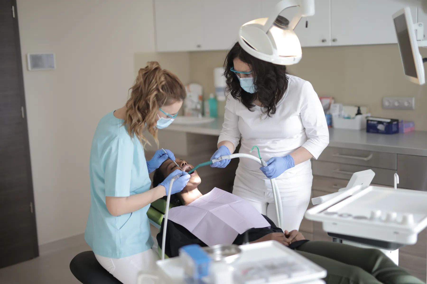 A dentist and assistant treating a relaxed patient