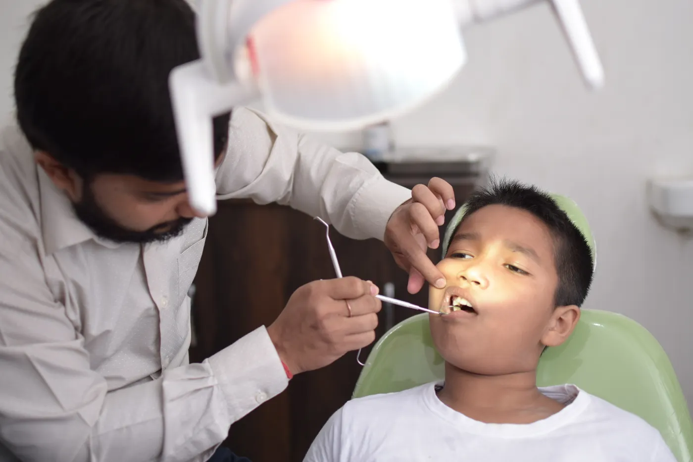 A dentist examining a young boy's teeth