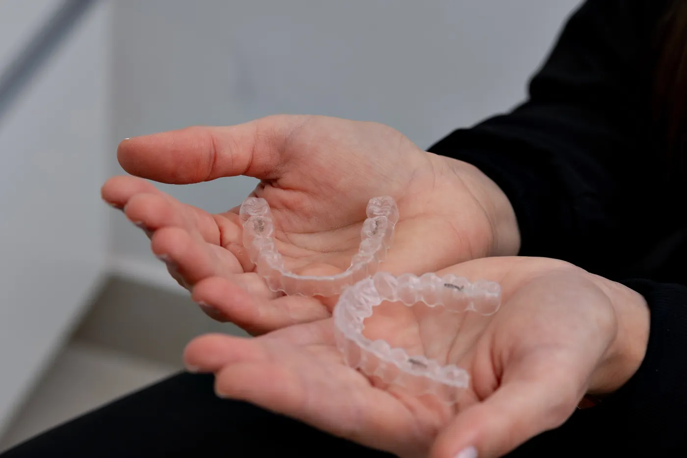 Clear aligners held in open hands